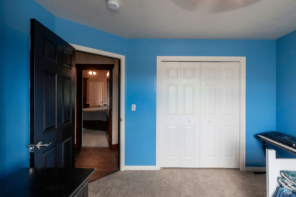 Carpeted bedroom featuring a closet and ceiling fan