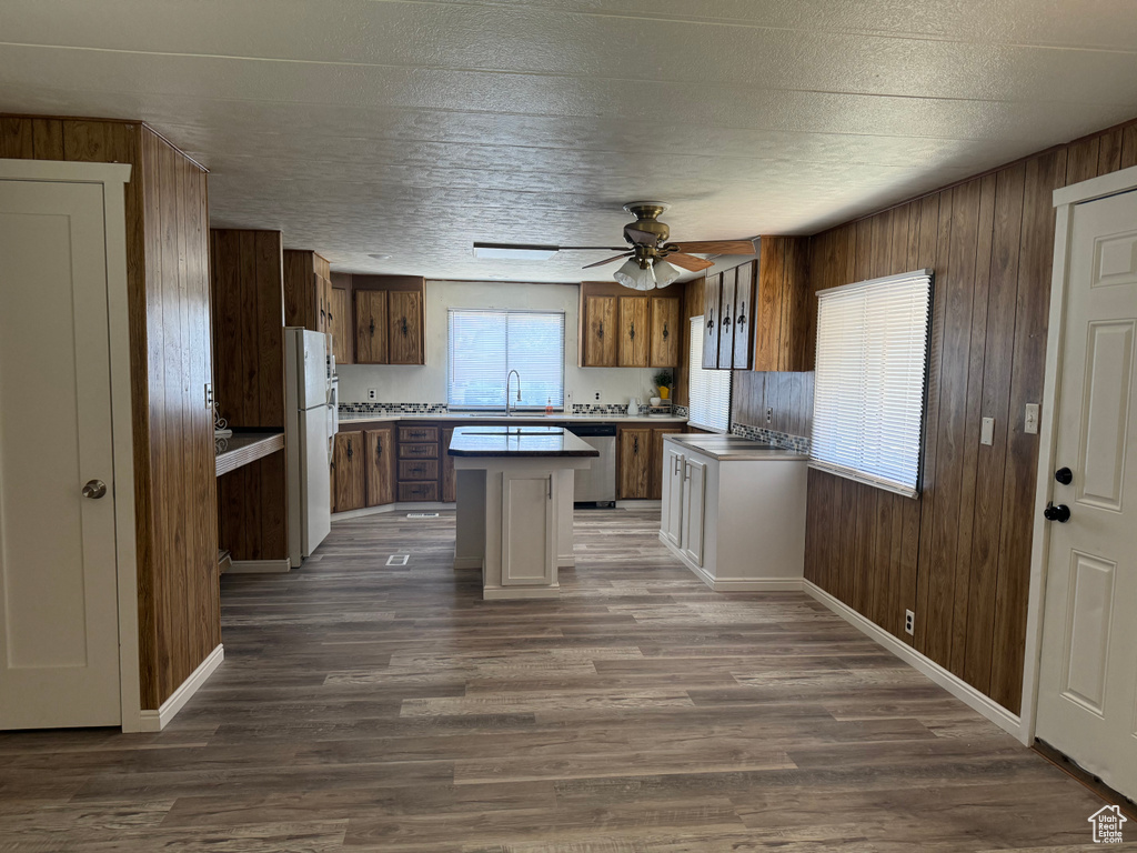 Kitchen with a kitchen island, ceiling fan, hardwood / wood-style floors, white fridge, and dishwasher