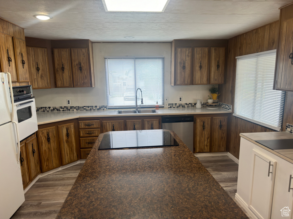 Kitchen with sink, hardwood / wood-style flooring, and white appliances