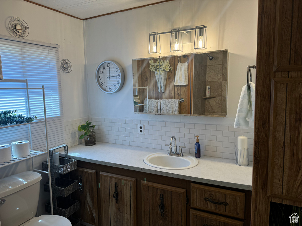 Bathroom with crown molding, backsplash, toilet, and vanity