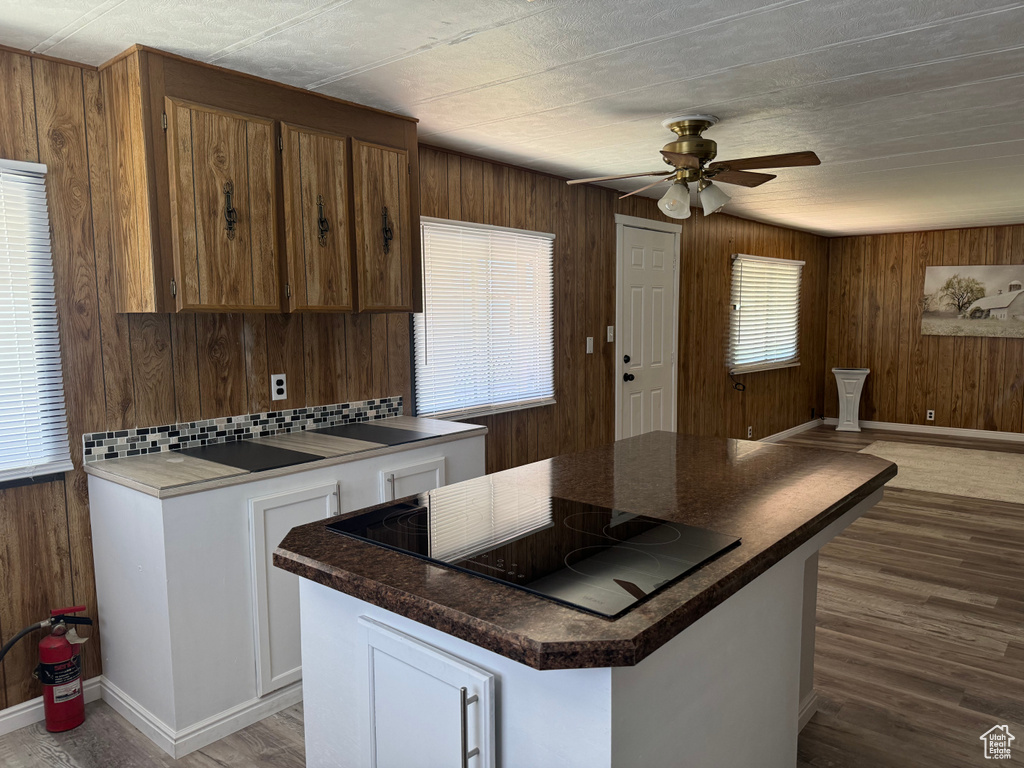 Kitchen featuring a healthy amount of sunlight, hardwood / wood-style floors, a center island, and ceiling fan