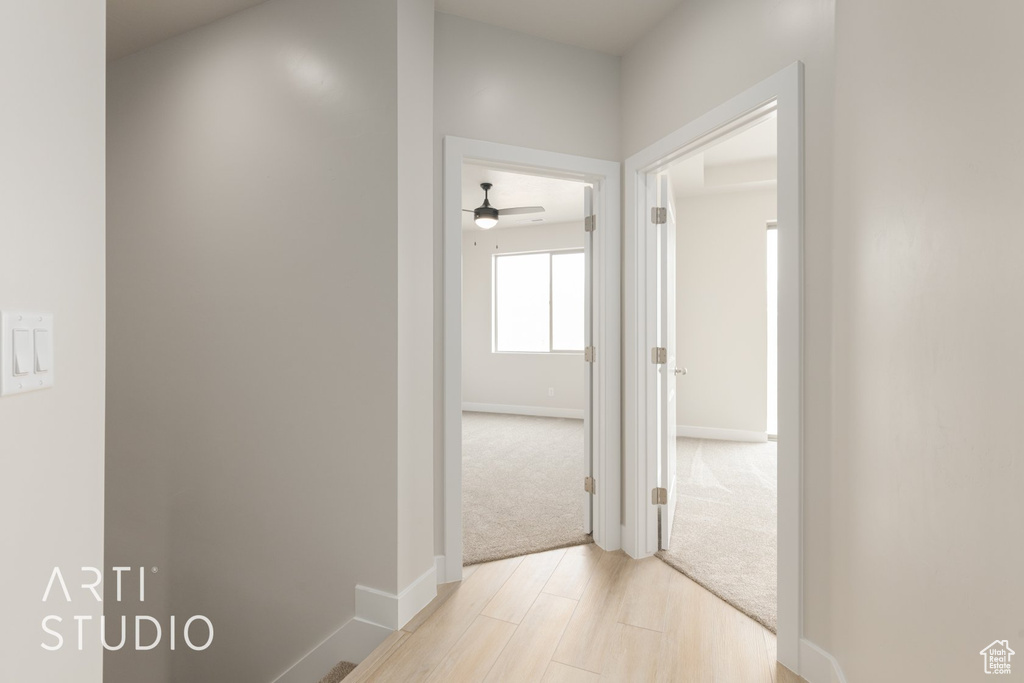 Corridor with light hardwood / wood-style flooring