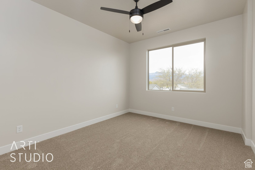 Carpeted empty room with ceiling fan