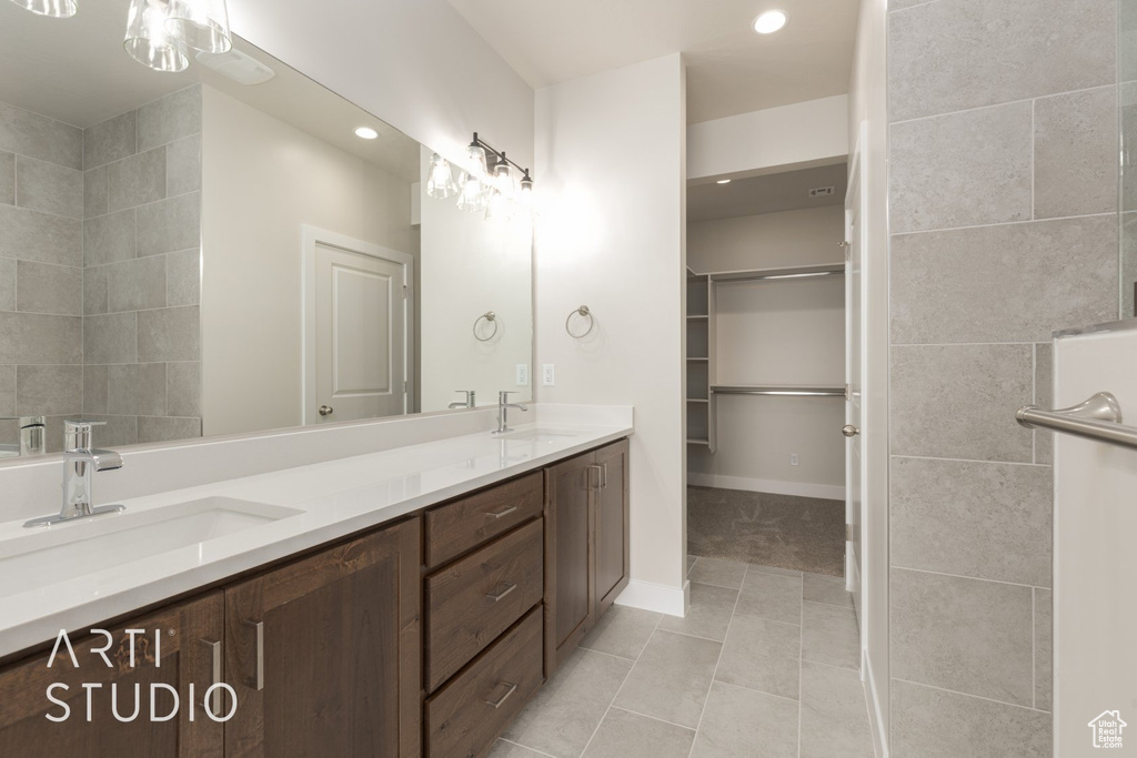 Bathroom featuring tile floors, large vanity, and double sink