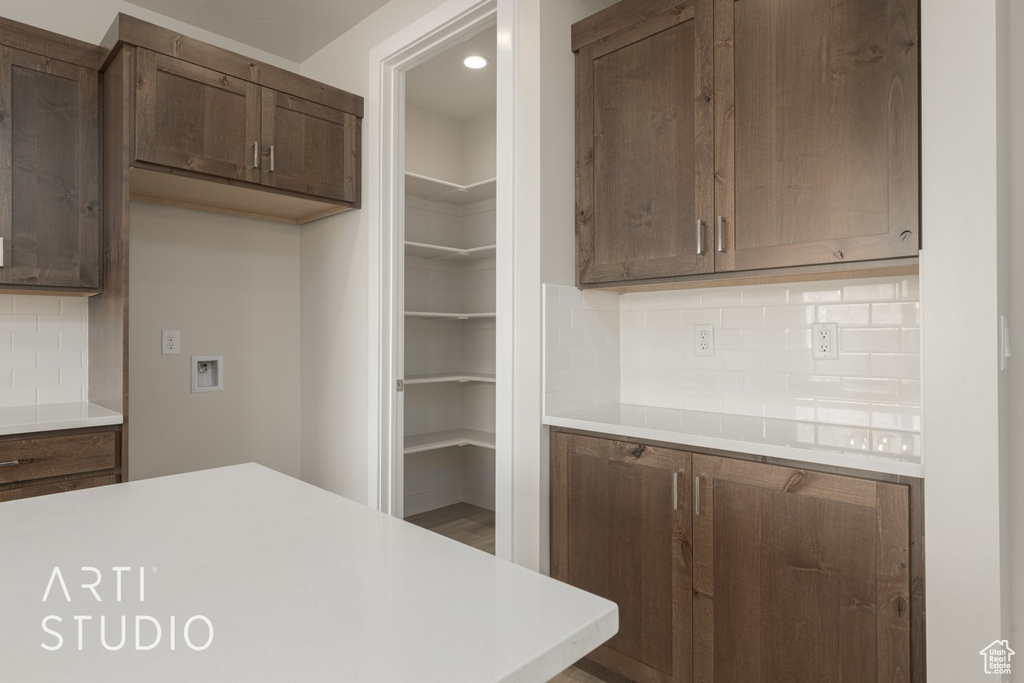 Kitchen featuring tasteful backsplash and dark brown cabinets