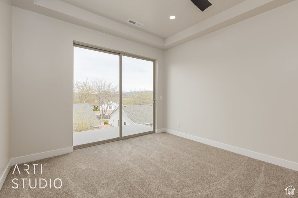 Unfurnished room with carpet and a tray ceiling