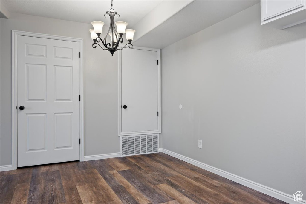 Interior space with a notable chandelier and dark wood-type flooring