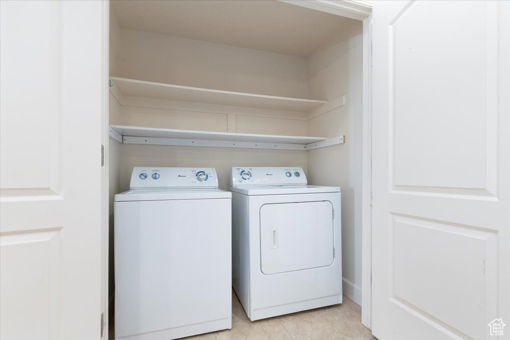 Laundry room featuring independent washer and dryer and light tile floors