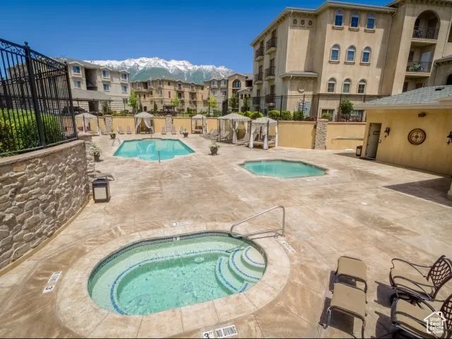 View of pool with a community hot tub and a patio