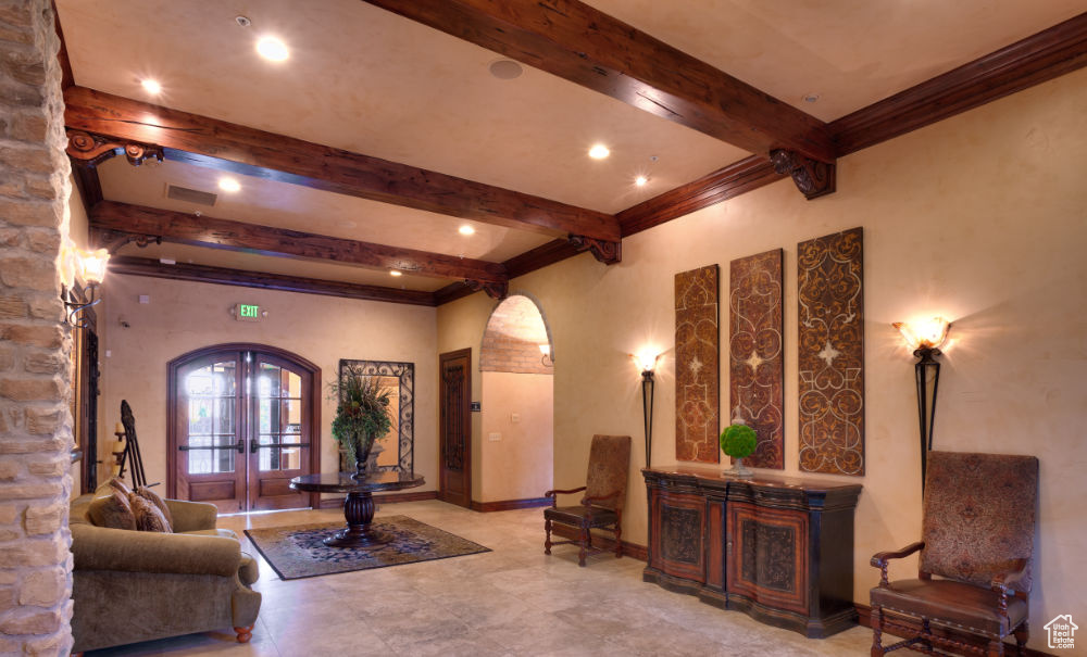 Tiled living room with beam ceiling and french doors