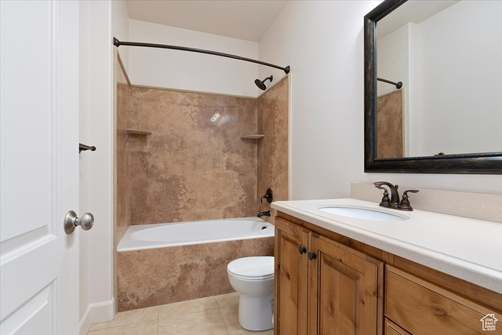 Full bathroom with tile floors, toilet, tiled shower / bath combo, and vanity