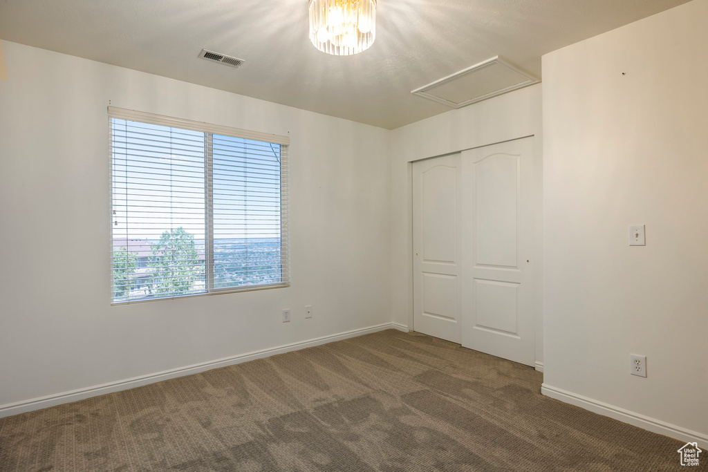 Unfurnished bedroom with dark colored carpet and a closet