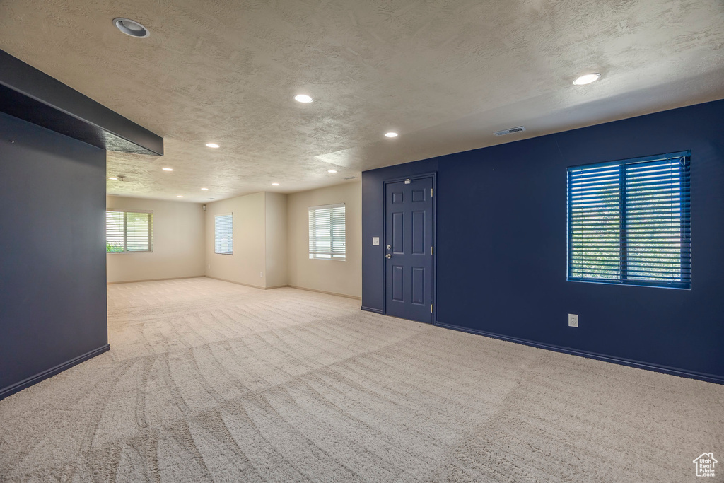 Carpeted spare room featuring a textured ceiling