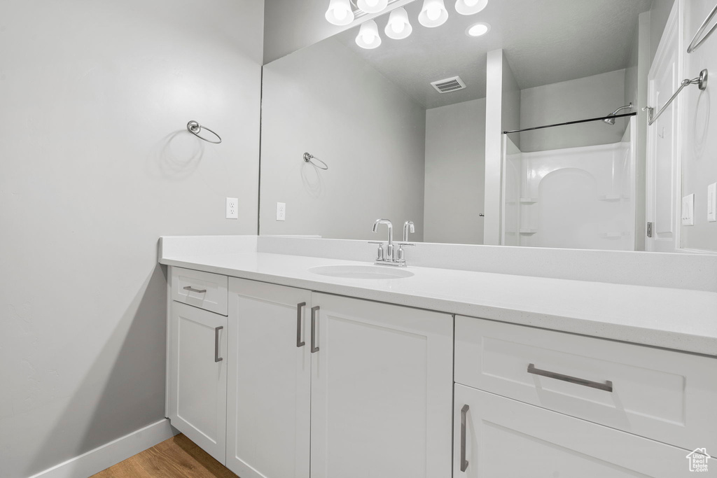 Bathroom with hardwood / wood-style flooring and vanity