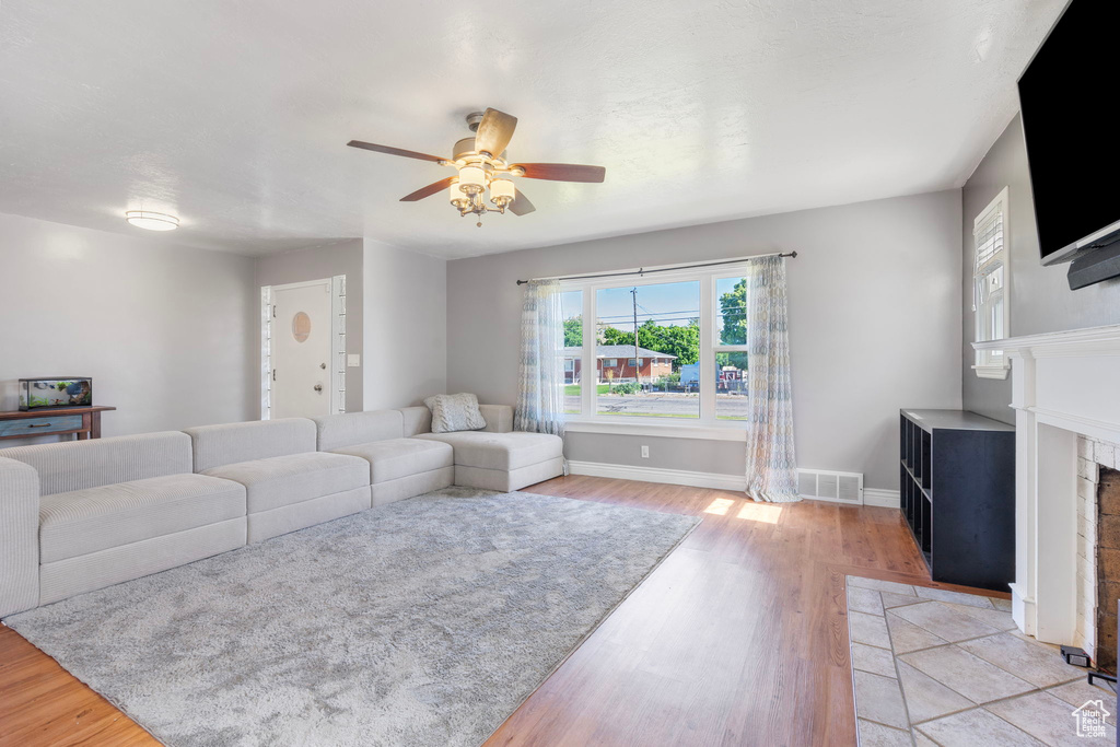 Living room with ceiling fan and light hardwood / wood-style flooring