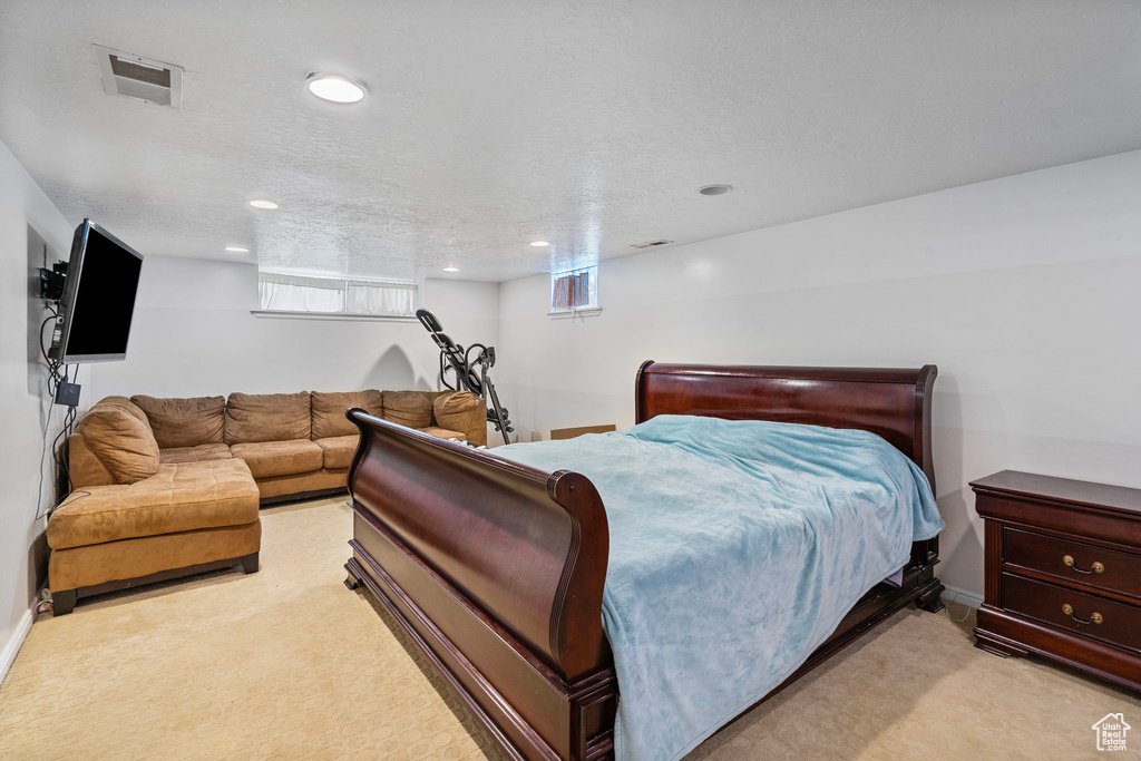 Bedroom with light carpet and a textured ceiling