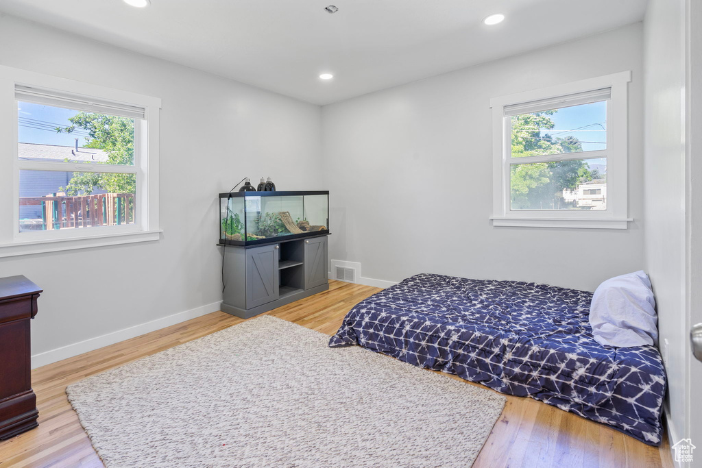 Bedroom featuring multiple windows and light hardwood / wood-style floors