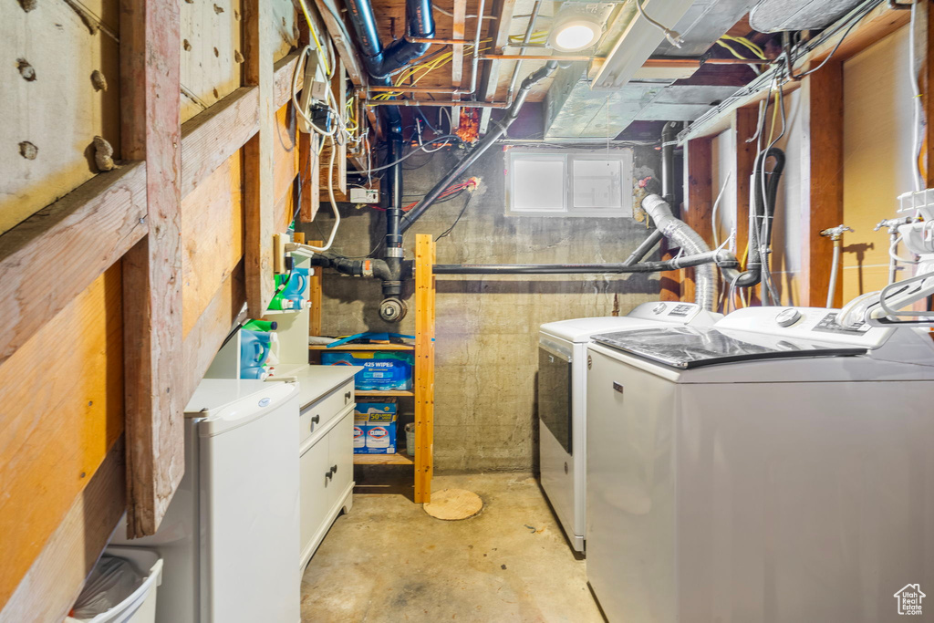 Washroom featuring cabinets and washing machine and clothes dryer