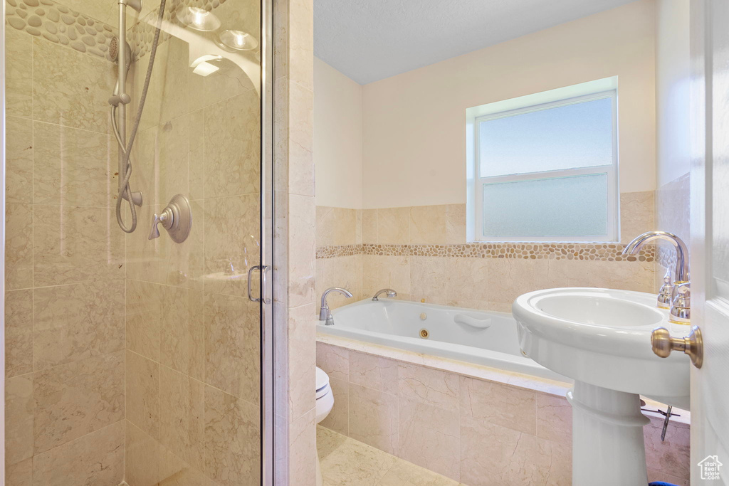 Bathroom featuring separate shower and tub and toilet