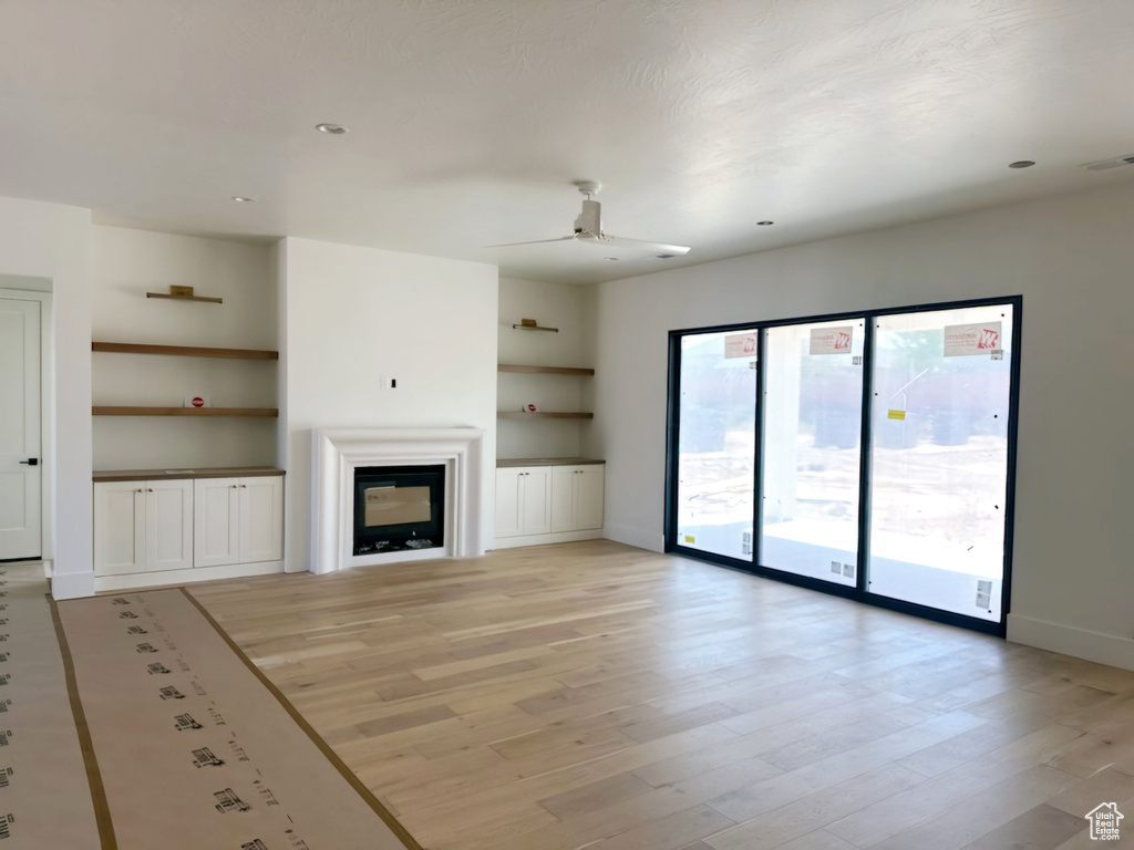 Unfurnished living room with ceiling fan and light hardwood / wood-style flooring