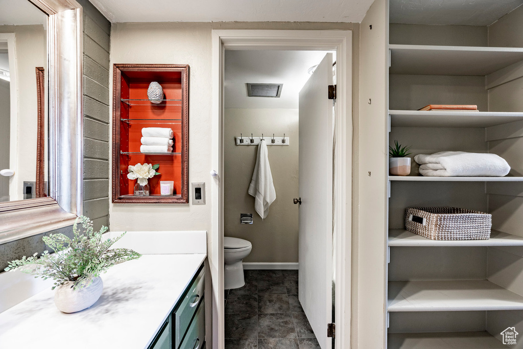 Bathroom with vanity, toilet, and tile floors