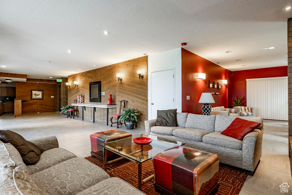 Living room featuring a textured ceiling and wood walls