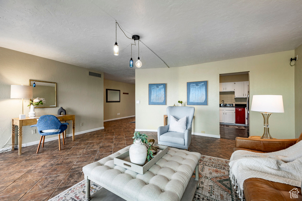 Living room with a textured ceiling and dark tile floors