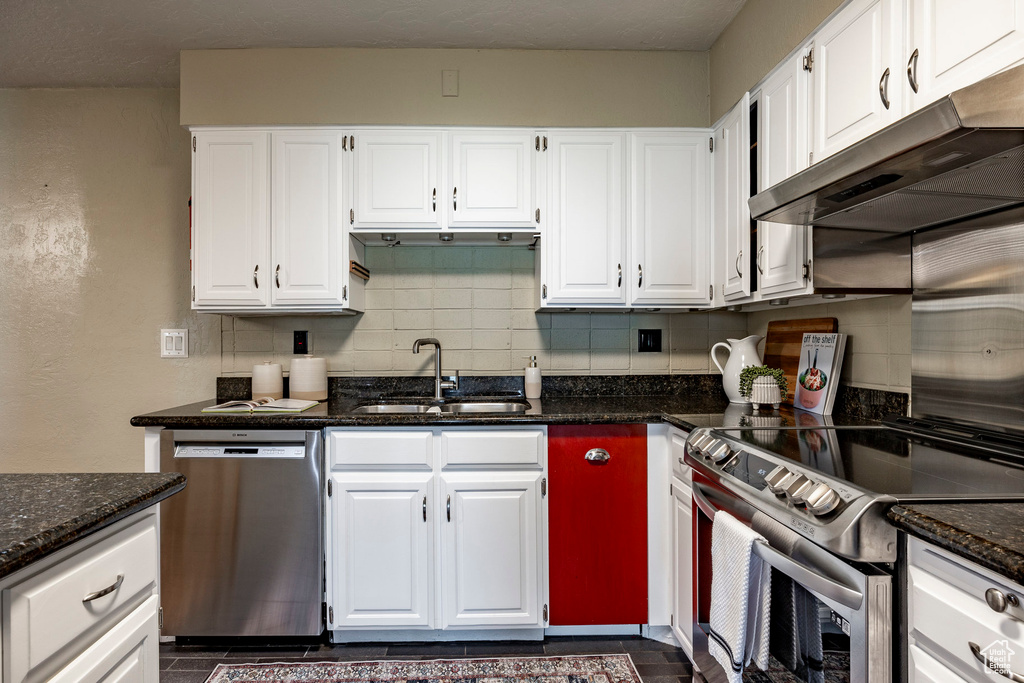 Kitchen featuring white cabinetry, stainless steel dishwasher, electric range oven, sink, and tasteful backsplash