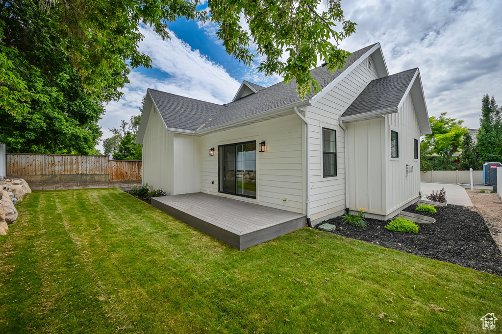 Back of house featuring a deck and a lawn