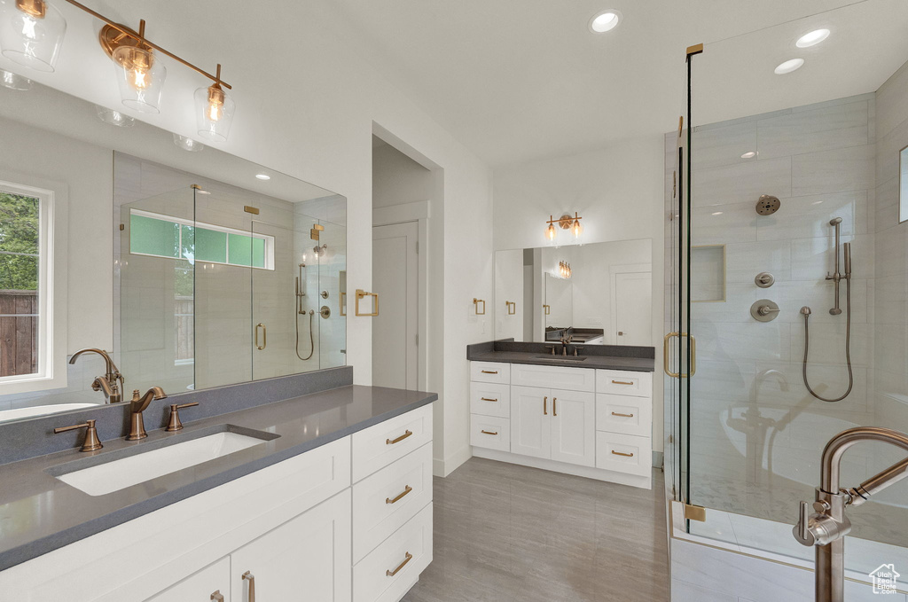 Bathroom with a shower with door, double sink, and oversized vanity