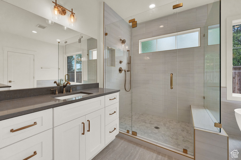 Bathroom with a wealth of natural light, vanity, and a shower with door