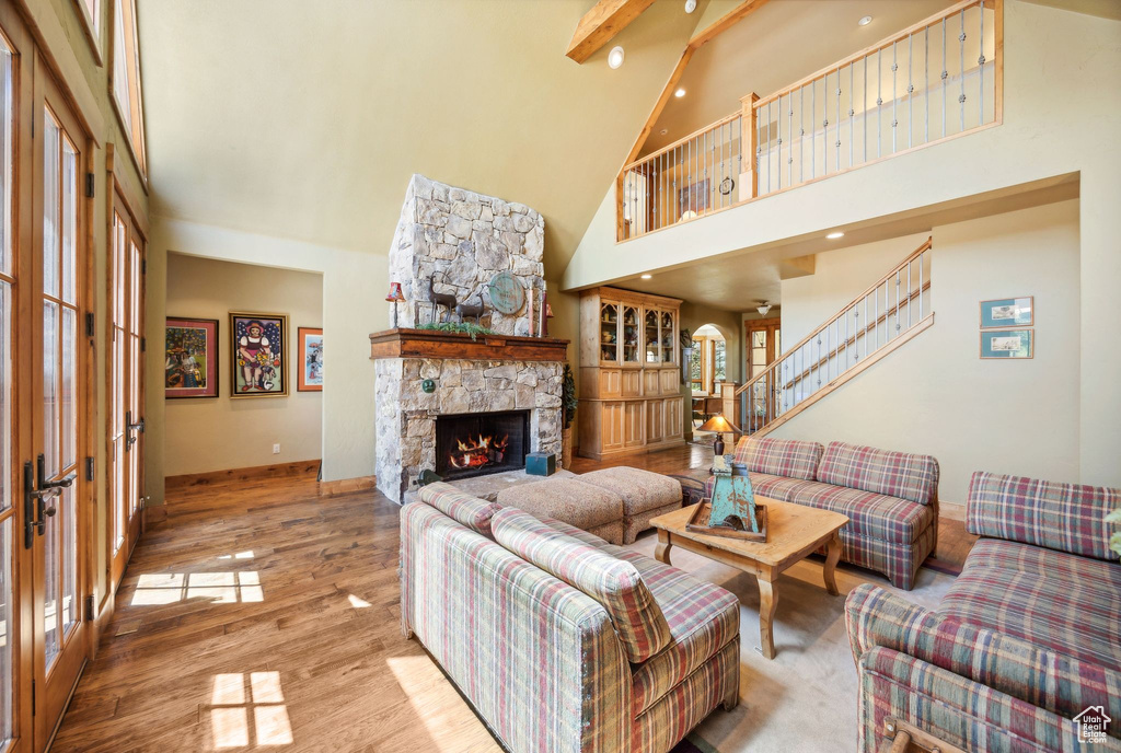 Living room featuring high vaulted ceiling, a fireplace, and hardwood / wood-style floors