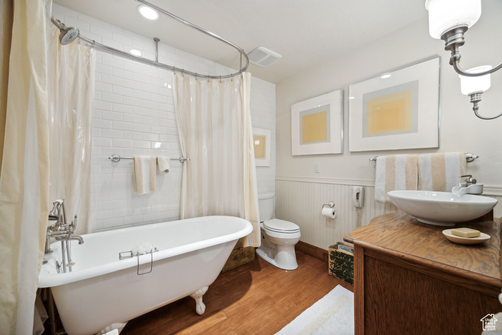 Bathroom with wood-type flooring, oversized vanity, and toilet