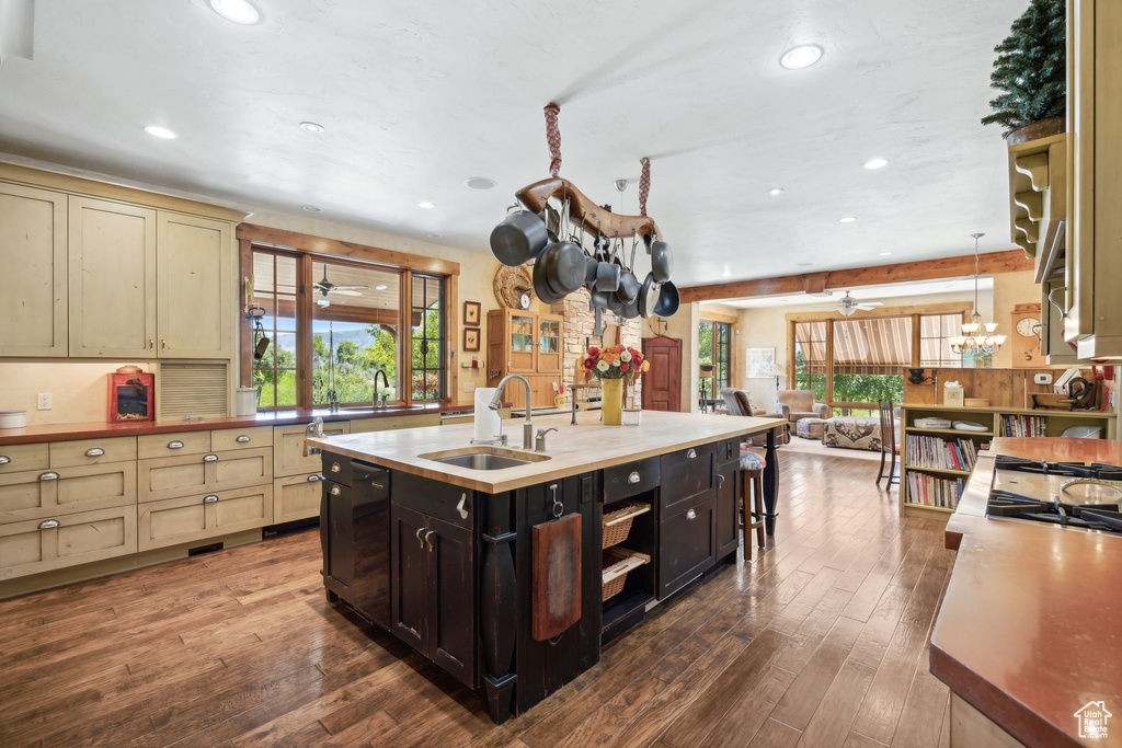 Kitchen with a kitchen island with sink, hardwood / wood-style floors, pendant lighting, sink, and ceiling fan