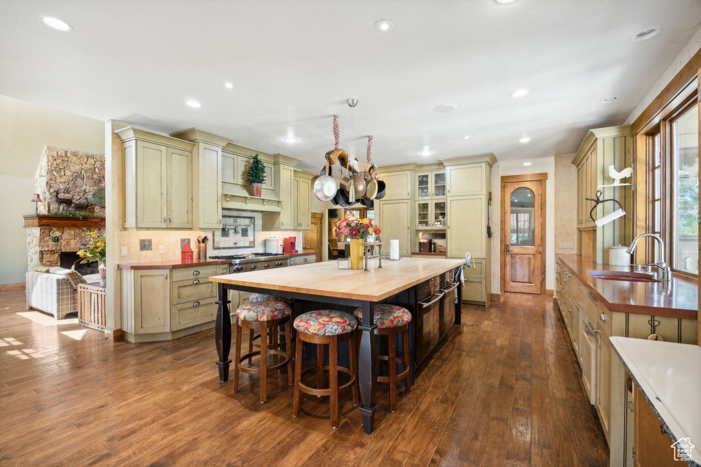 Kitchen featuring dark hardwood / wood-style floors, sink, a kitchen island, and butcher block countertops