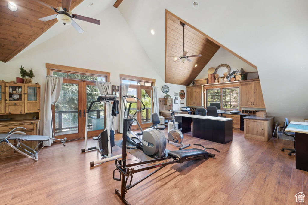 Exercise room featuring high vaulted ceiling, hardwood / wood-style flooring, ceiling fan, and french doors