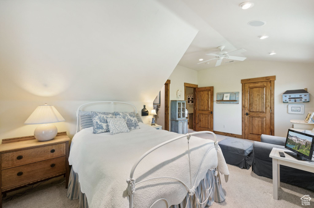 Carpeted bedroom with vaulted ceiling and ceiling fan