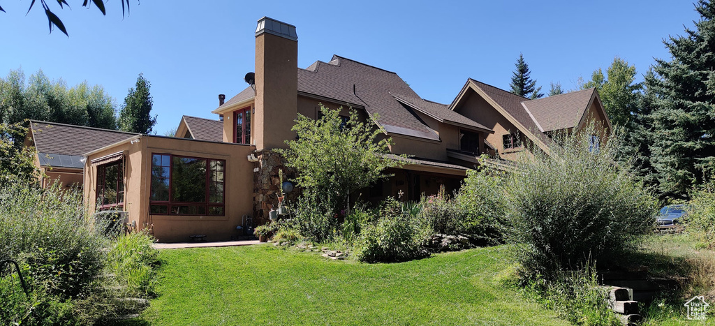 Rear view of house featuring a yard