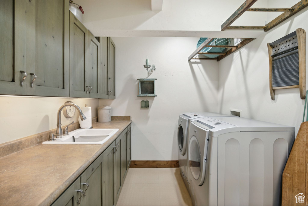 Laundry room with cabinets, light tile flooring, washing machine and clothes dryer, hookup for a washing machine, and sink