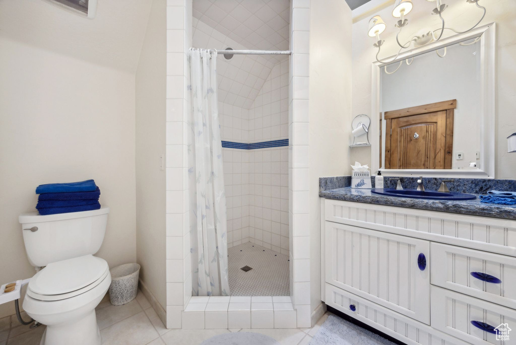 Bathroom featuring walk in shower, tile flooring, toilet, and vanity