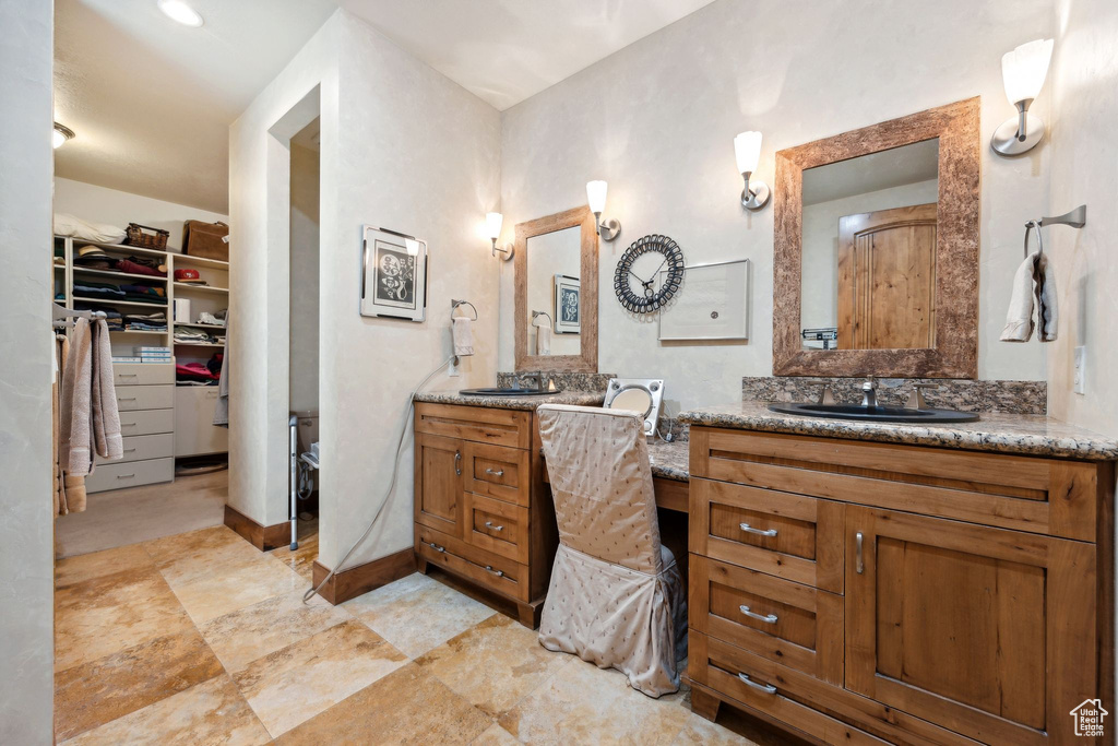 Bathroom featuring vanity with extensive cabinet space and tile flooring