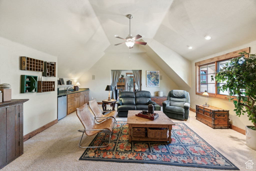 Living room featuring light carpet, ceiling fan, and vaulted ceiling