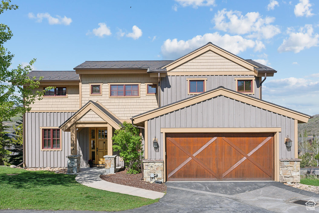 View of front of house featuring a garage and a front lawn