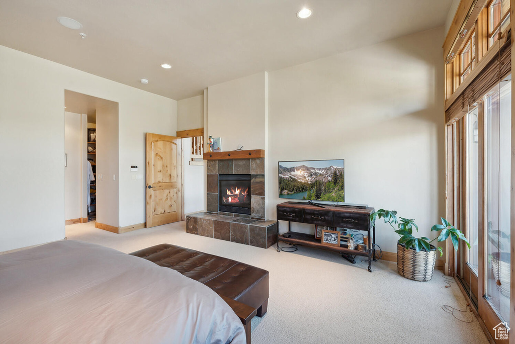 Bedroom with a tile fireplace and light carpet