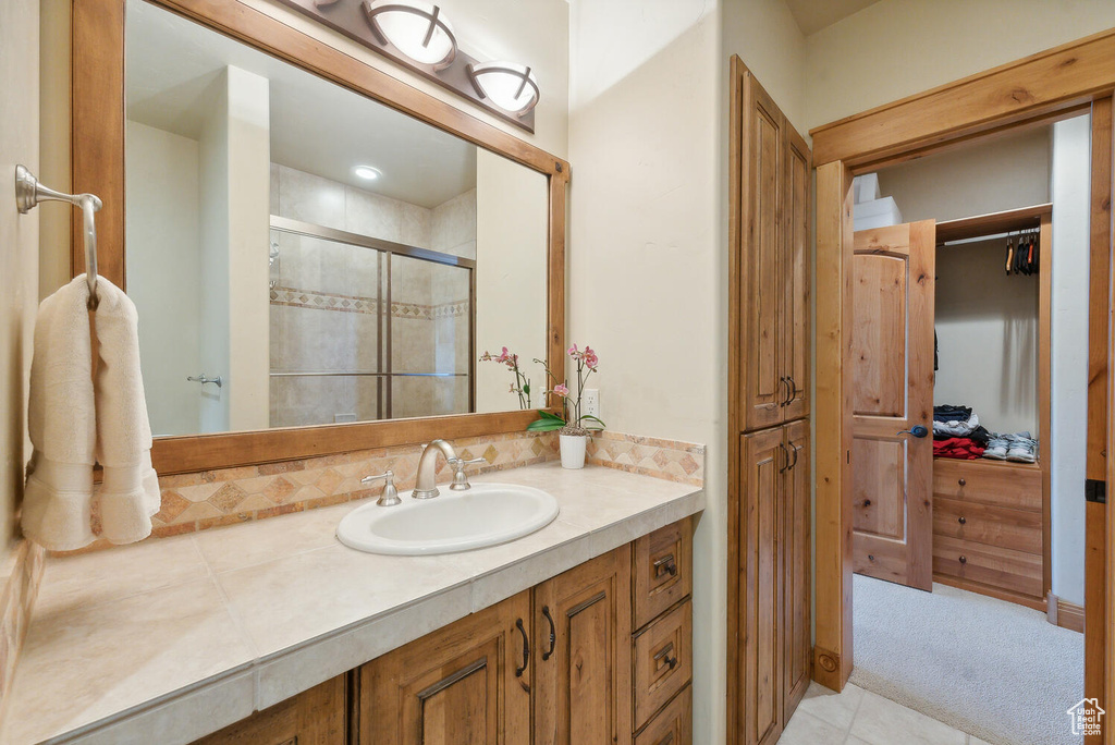 Bathroom with an enclosed shower, tile flooring, and oversized vanity