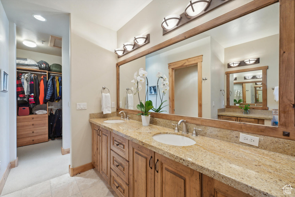 Bathroom with oversized vanity, double sink, and tile floors