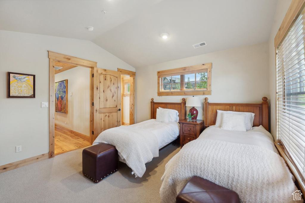 Bedroom featuring vaulted ceiling and light colored carpet