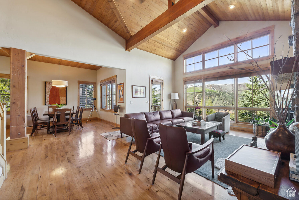 Dining space featuring high vaulted ceiling, beamed ceiling, hardwood / wood-style floors, and wood ceiling