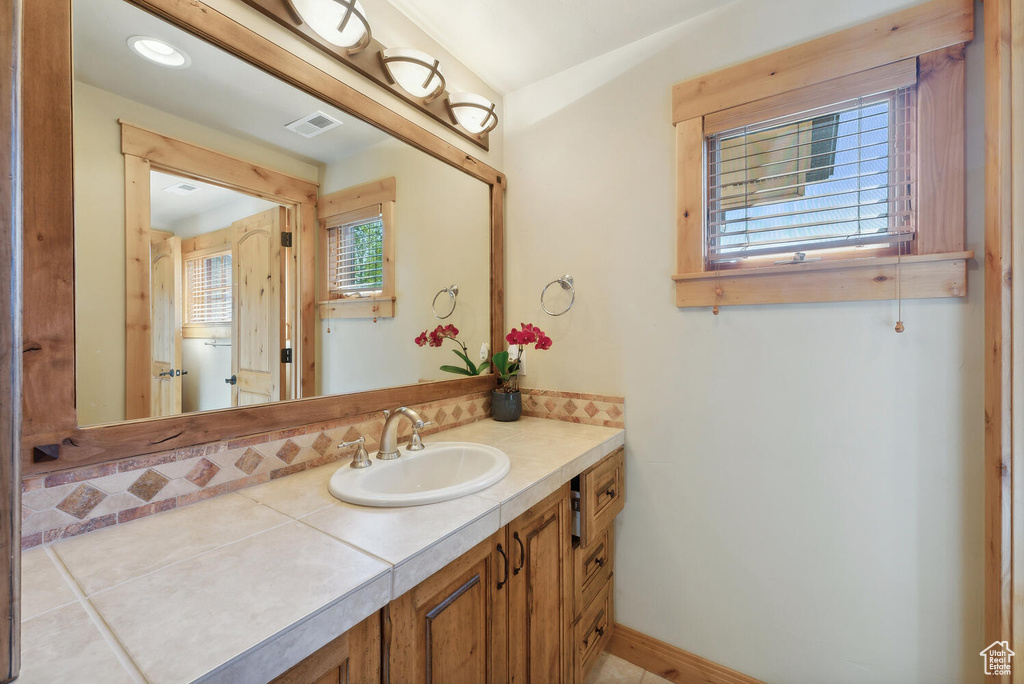 Bathroom featuring vanity with extensive cabinet space