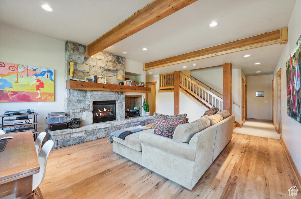 Living room featuring beam ceiling, light hardwood / wood-style floors, and a fireplace